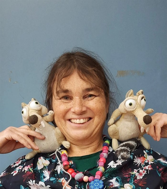 Ingrid Bouma lacht met twee speelse knuffeldieren op haar schouders